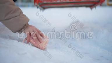 冬天，女人用手从雪道捡钱包. 在冬天的街道上，手拿钱包躺在雪地上